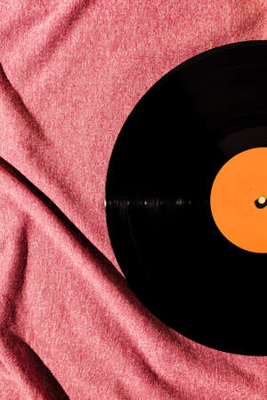 Flat lay of LP vinyl record on a pink fabric cloth background.  Old vintage record.の写真素材