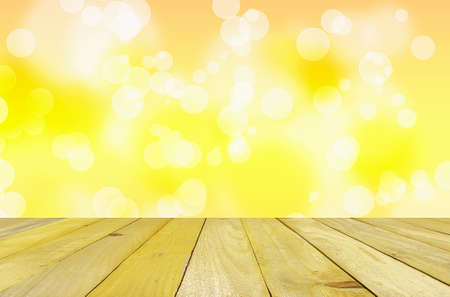 Magical bokeh lights effect background. Colorful defocused lights with empty wooden table.の写真素材