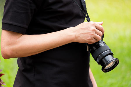 the man hold a black camera with his right hand