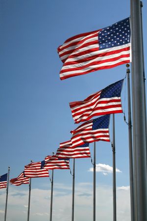 American flags flying with blue sky background.の写真素材