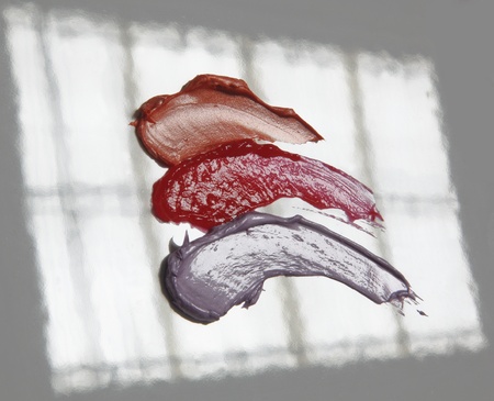 Lipstick samples of different colors isolated on white background