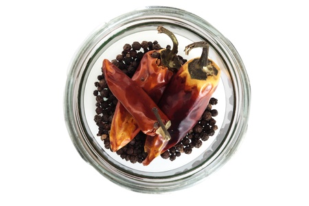 Dried red chilis pepper in a glass jar on a white backgroundの写真素材