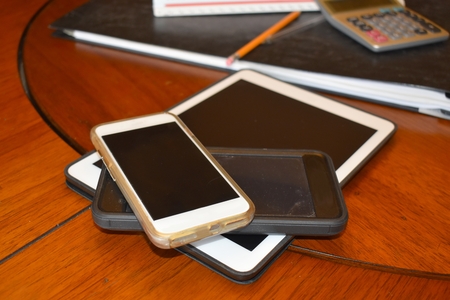 Electronic devices including tablets phones at work stationの写真素材