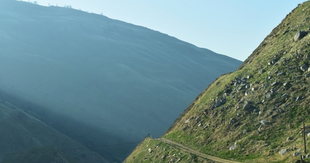 Crisp mountain side with foggy mountain in the background