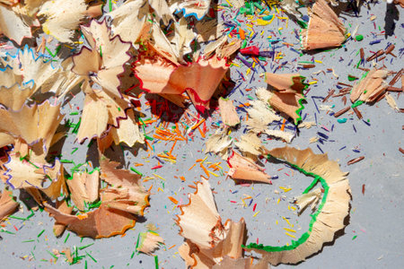 Shavings of colored pencils on metal gray background