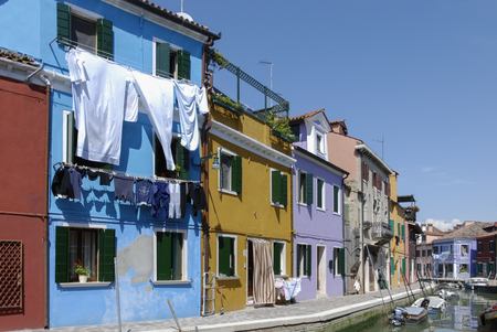 BURANO - ITALY, APRIL 18, 2009: Panoramic view of colorful buildings and boats in front of a canal at Burano, a gracious small town full of canals near Venice.のeditorial素材
