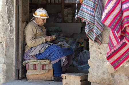 TARABUCO, BOLIVIA - AUGUST 06, 2017: Unidentified indigenous native Quechua woman with traditional tribal clothing and hat, at the local Tarabuco Sunday Market, Bolivia - South Americaのeditorial素材