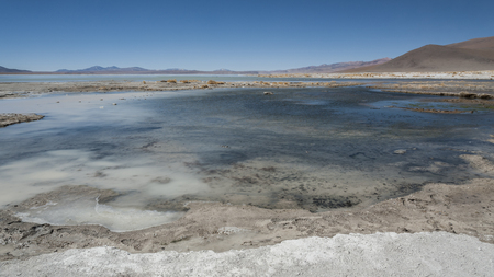 Laguna y Termas de Polques hot spring pool with Salar de Chalviri in the background, Salar de Uyuni, Potosi, Bolivia - South Americaの写真素材