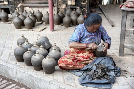 BHAKTAPUR, NEPAL AUGUST 13, 2018: Nepalese woman making pottery in Pottery square, a public square...