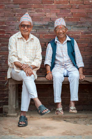 PATAN, LALITPUR, NEPAL - AUGUST 15, 2018: Unidentified Newari elderly men sit in front of the Mul...