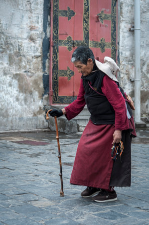 LHASA, TIBET, CHINA - AUGUST, 17 2018: Unidentified Tibetan pilgrim performing the Barkhor Kora (walking in clockwise direction around the Jokhang Temple)のeditorial素材