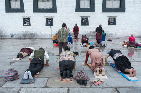 LHASA, TIBET, CHINA - AUGUST, 17 2018: Pilgrims praying worshipping in front of Jokhang temple. The...