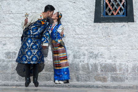 LHASA, TIBET, CHINA - AUGUST, 17 2018: Unidentified Tibetan couple in front of Jokhang temple. The...