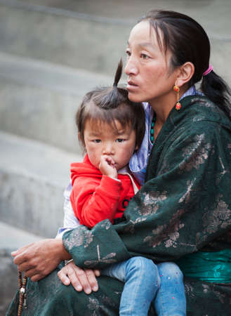 LHASA, TIBET, CHINA - AUGUST, 17 2018: Unidentified Tibetan pilgrims with with typical clothing near the old Jokhang Temple in Lhasa, Tibetのeditorial素材