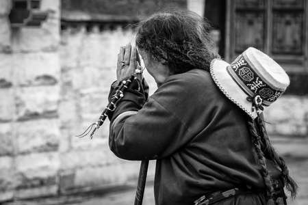 LHASA, TIBET, CHINA - AUGUST, 17 2018: Pilgrim praying worshipping in front of Jokhang temple. The...