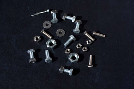 A group of metal products, bolts, nuts and washers on dark velvet surfaceの写真素材