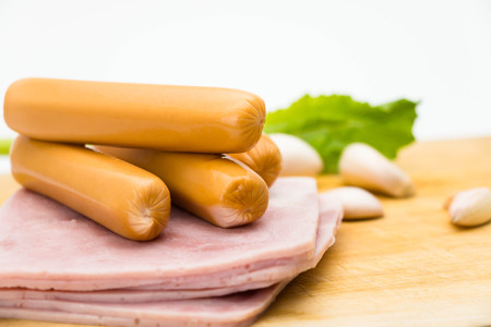 hams and sausage on wooden cutting board