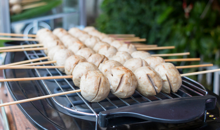 grilled meatballs with spicy sauce represent street food in Thailandの写真素材