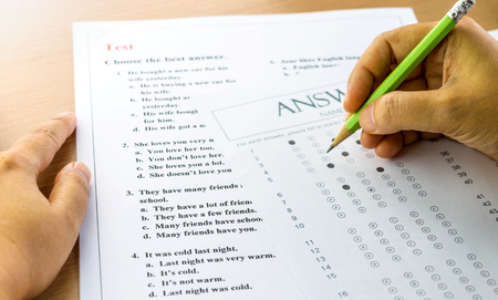 english questions and answer sheet on table with handsの写真素材