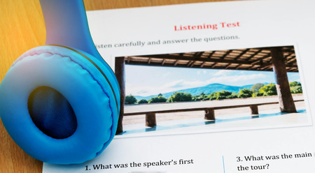 blue headphone and listening english test on table