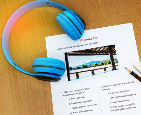 blue headphone and listening english test on table