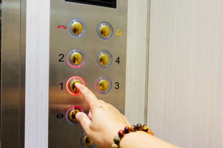 hand touch button number in elevator
