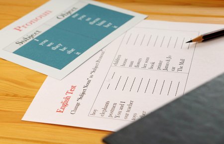 English test sheet on wooden desk represent school test in classroomの写真素材