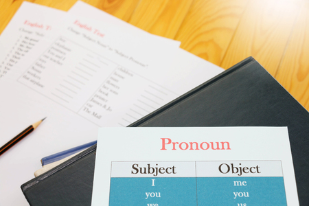 English test sheet on wooden desk represent school test in classroomの写真素材