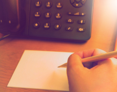 hand holding pencil writing note on notepadの写真素材