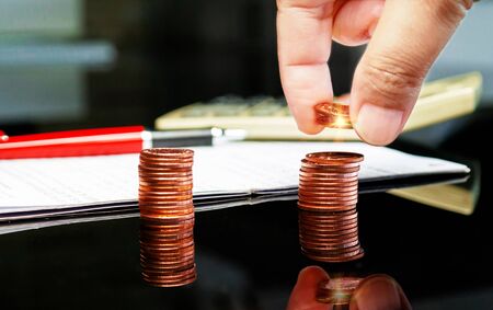 hand holding coins over row of coin concept represent income or payment