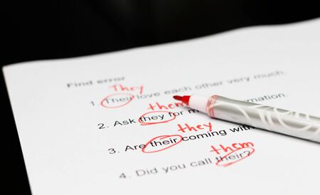 proofreading paper with red mark errors on table