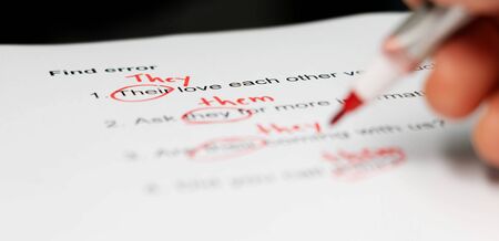 proofreading paper with red mark errors on table