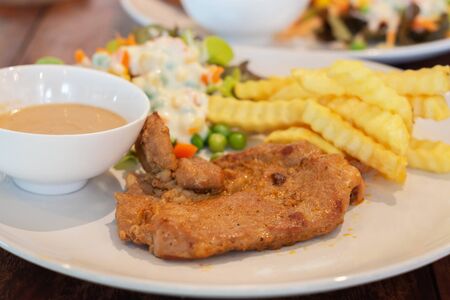new fresh pork steak on white plate with salad and french friesの写真素材