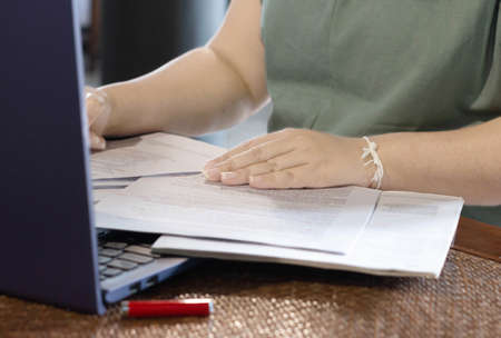 woman's hand on paperwork represent working in office or home