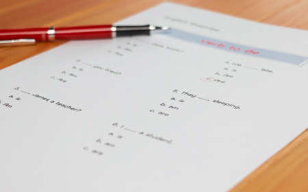 English grammar test sheet on wooden table in classroomの写真素材