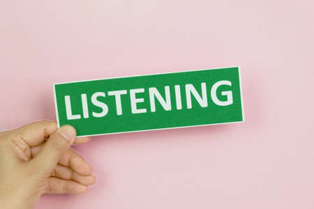 hand holding colorful sign of English learning skills over colorful wallの写真素材