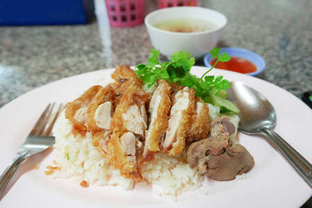 traditional fried chicken rice with soup and sauce on table in food shopの写真素材