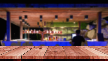 perspective wooden board bar over blurred beverage counter bar in restaurant at nightの写真素材