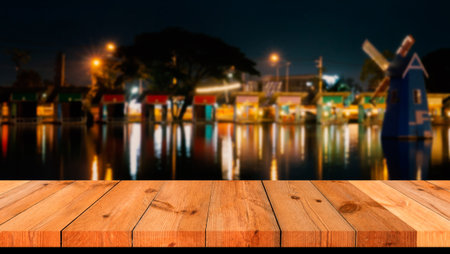 perspective brown wooden board over blurred view and water reflection in darkの写真素材
