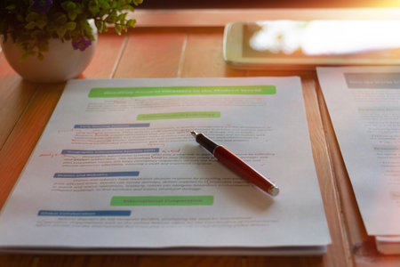 proofreading worksheet on brown wooden table in summerの写真素材