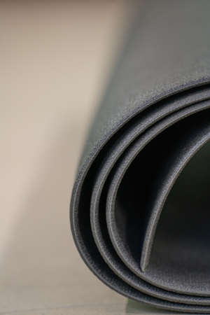 A black yoga and Pilates mat lies on the gym floorの写真素材
