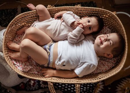 newborn baby with toddler boy brother laying in straw cradle. Lifestyle