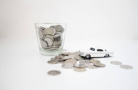 close up stack of coin and toy car on white background, saving money for future, manage to success transport business technology concept. finance conceptの写真素材