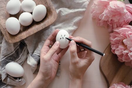 hands drawing geometric monochrome pattern on easter eggs. easter holiday conceptの写真素材