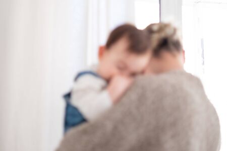 Defocused mother holding an infant baby background. Family lifestyleの写真素材