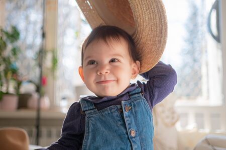 Little infant girl in straw hat smiling and laughing. Family lifestyleの写真素材