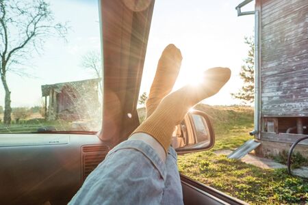 womans toes in car window with sun. road trip concept. freedom and travelの写真素材