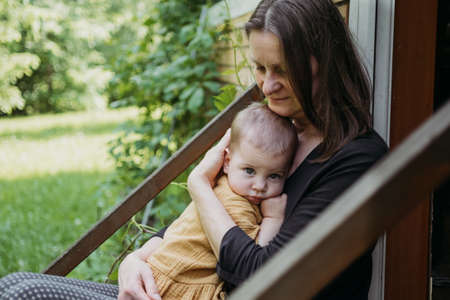 mother holding a toddler baby outdoorsの写真素材