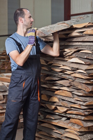 Man arraging beech planks in a warehouse. Vertical shot.の写真素材