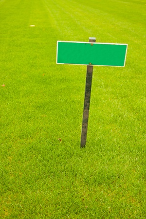 Green grass with a sign, vertical shot with copy spaceの写真素材